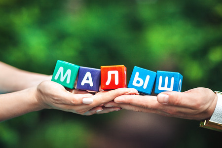 Female and male hand holding baby signの写真素材