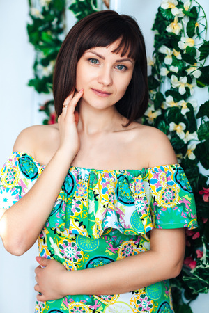 Close-up of a women in a bright summer dress looks and posesの写真素材