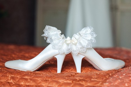 The garter of the bride lies on wedding shoesの写真素材