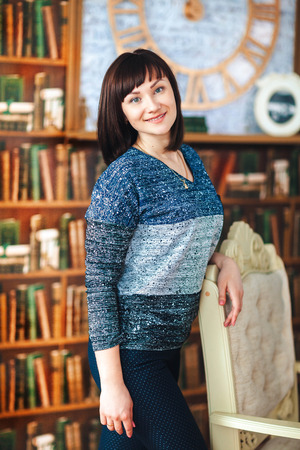 Portrait of a woman on the background of a bookshelfの写真素材