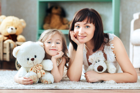 Happy mother and daughter in a children's roomの写真素材