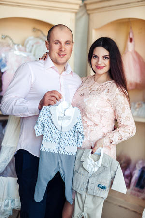 Husband and pregnant wife look at children's thingsの写真素材