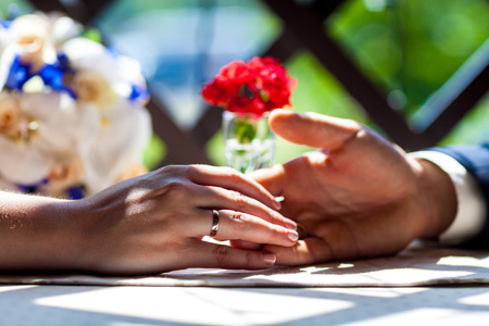 Newly wed couple's hands with wedding ringsの写真素材