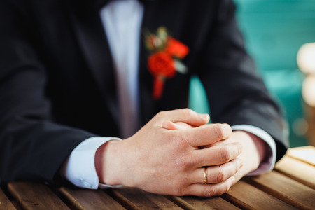 Hands of the bridegroom with wedding ringの写真素材