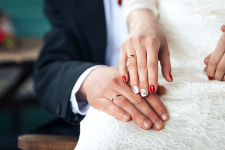 Newly wed couple's hands with wedding ringsの写真素材