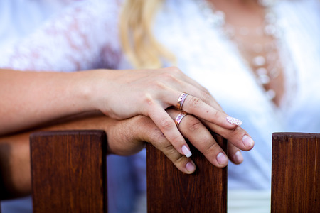 Newly wed couple's hands with wedding ringsの写真素材