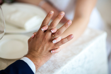 Newly wed couple's hands with wedding ringsの写真素材