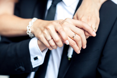 Newly wed couple's hands with wedding ringsの写真素材