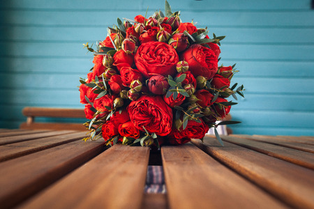 Wedding bouquet of red roses on a blue backgroundの写真素材