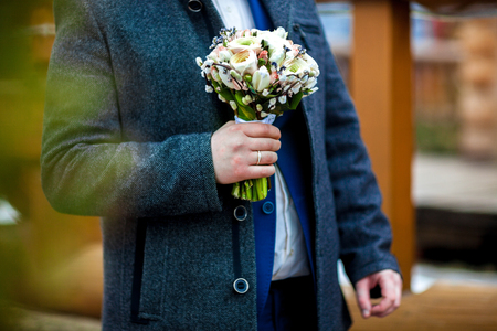 Hand of the groom holding a bouquetの写真素材