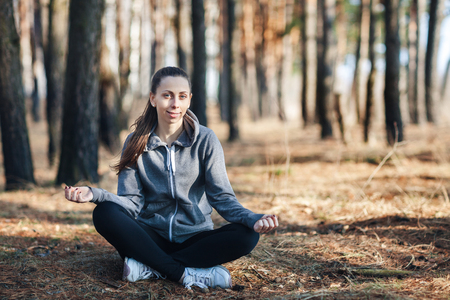 girl doing yoga in park on autumn dayの写真素材
