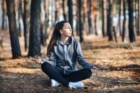 girl doing yoga in park on autumn dayの写真素材