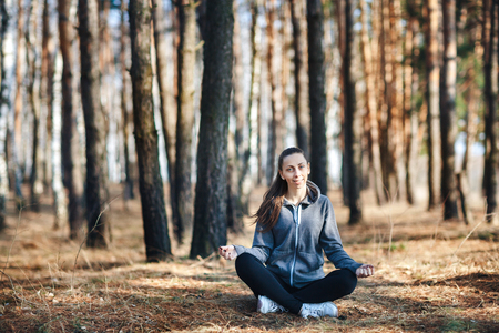 girl doing yoga in park on autumn dayの写真素材