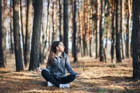 girl doing yoga in park on autumn dayの写真素材