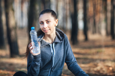 Woman holding a bottle of cold water in her hand.の写真素材