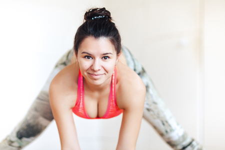 A girl of sports appearance, relaxes, looks into the camera, does warm-up and stretching, close-upの写真素材