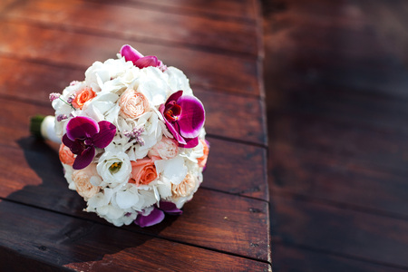 a bouquet of brides from white roses and rose-roses violets lies on a wooden backgroundの写真素材