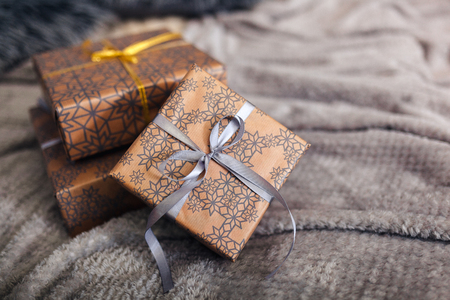 three gift box over beige bed closeup. Christmas tree purple ribbon and beige paperの写真素材