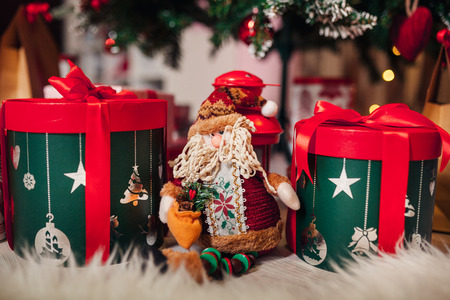 Santa Claus figurine with Christmas gifts under the tree