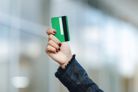 closeup of green credit card holded by woman hand.の写真素材