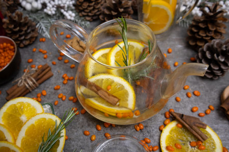 Tea with sea buckthorn berries, lemon and rosemary on a gray backgroundの写真素材