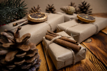 Christmas gifts wrapped in kraft paper and tied with twine on wooden backgroundの写真素材