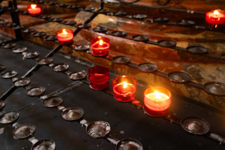 Lit candles on a platform in the church, creating a serene and peaceful atmosphere.の写真素材