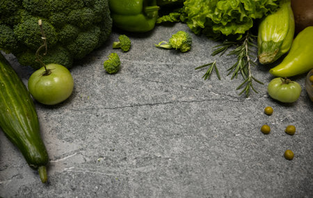 Green vegetables arranged on a grey table, showcasing healthy food and fresh ingredients for a nutritious lifestyle.の写真素材