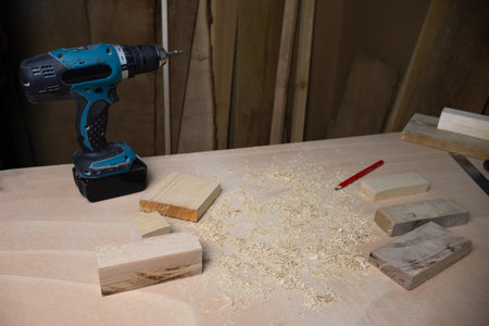 Carpentry workshop with wood pieces and a drilling machine, representing woodworking, craftsmanship,...