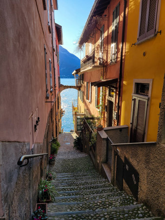 Narrow street leading down to Lake Como in Italy, offering a charming and scenic view of the lake and surrounding area.の写真素材