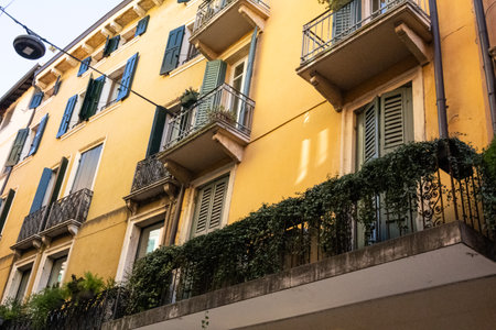 Exterior view of beautiful historical buildings in Verona, Italy, showcasing colorful Mediterranean architecture on a charming urban street.の写真素材