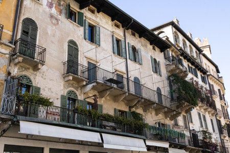 Exterior view of beautiful historical buildings in Verona, Italy, showcasing colorful Mediterranean architecture on a charming urban street.の写真素材