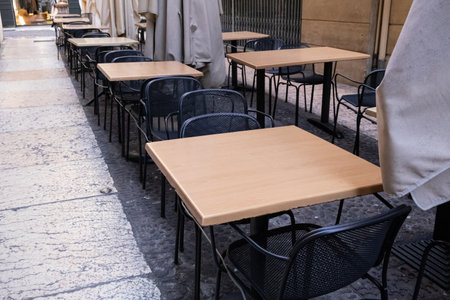 Terrace with tables and chairs in the street, offering a relaxing outdoor space for dining and...