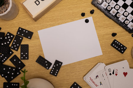Playing cards with a message on a game background featuring chess and domino piecesの写真素材