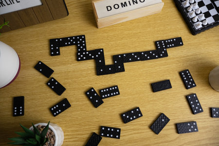Domino game pieces arranged on a wooden desk, creating a playing background