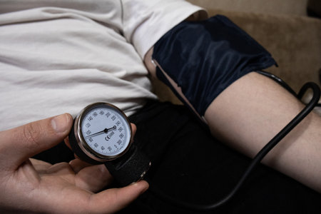 Close-up of male hands using a manual tonometer to check blood pressure, healthcare and wellness monitoringの写真素材