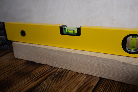 Spirit level on a piece of wood, close-up, precision, carpentry, tool, measurement, leveling,...