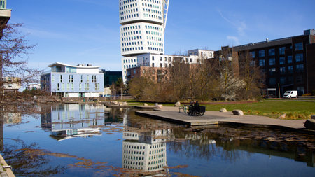 Vertical frame of the Turning Torso building reflected in a sea canal in Malm
