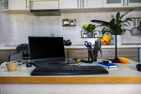 Interior of a modern kitchen with laptop computer and cup of coffee