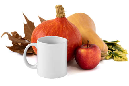 A closeup shot of a white mug, apple and pumpkins on white background. Mockup scene.の写真素材