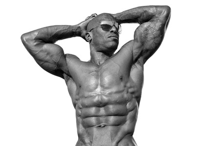 Strong bodybuilder man with perfect abs, shoulders,biceps, triceps and chest, personal fitness trainer flexing his musclesの写真素材