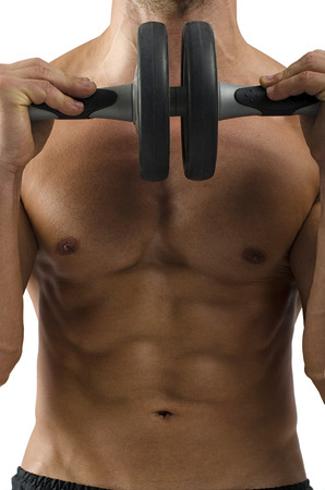 Close up on perfect abs. Strong bodybuilder with six pack and holding an abs rollerの写真素材