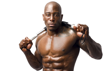 Strong bodybuilder man with perfect abs, shoulders,biceps, triceps and chest, personal fitness trainer flexing his muscles and training with a flexing barの写真素材