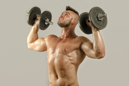 Strong bodybuilder man with perfect abs, shoulders,biceps, triceps and chest, personal fitness trainer flexing his musclesの写真素材