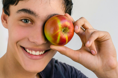 Young man choosing to eat an organic, healthy apple for a perfect dietの写真素材