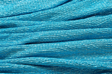 Crumpled blue and silver sparkly textured fabric.の写真素材