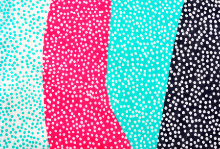 Closeup on white dots on navy blue, pink and turquoise green background texture.の写真素材