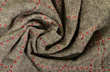 Wool fabric with red sewing and a leather triangle. Tartan design as background. Checked fabric.の写真素材