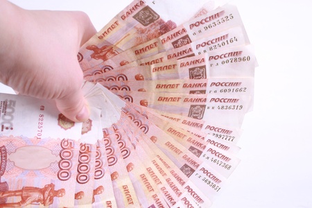 A hand holding a bunch of Russian banknotes