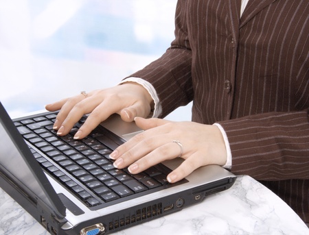 Hands of business person on notebook keyboardの写真素材